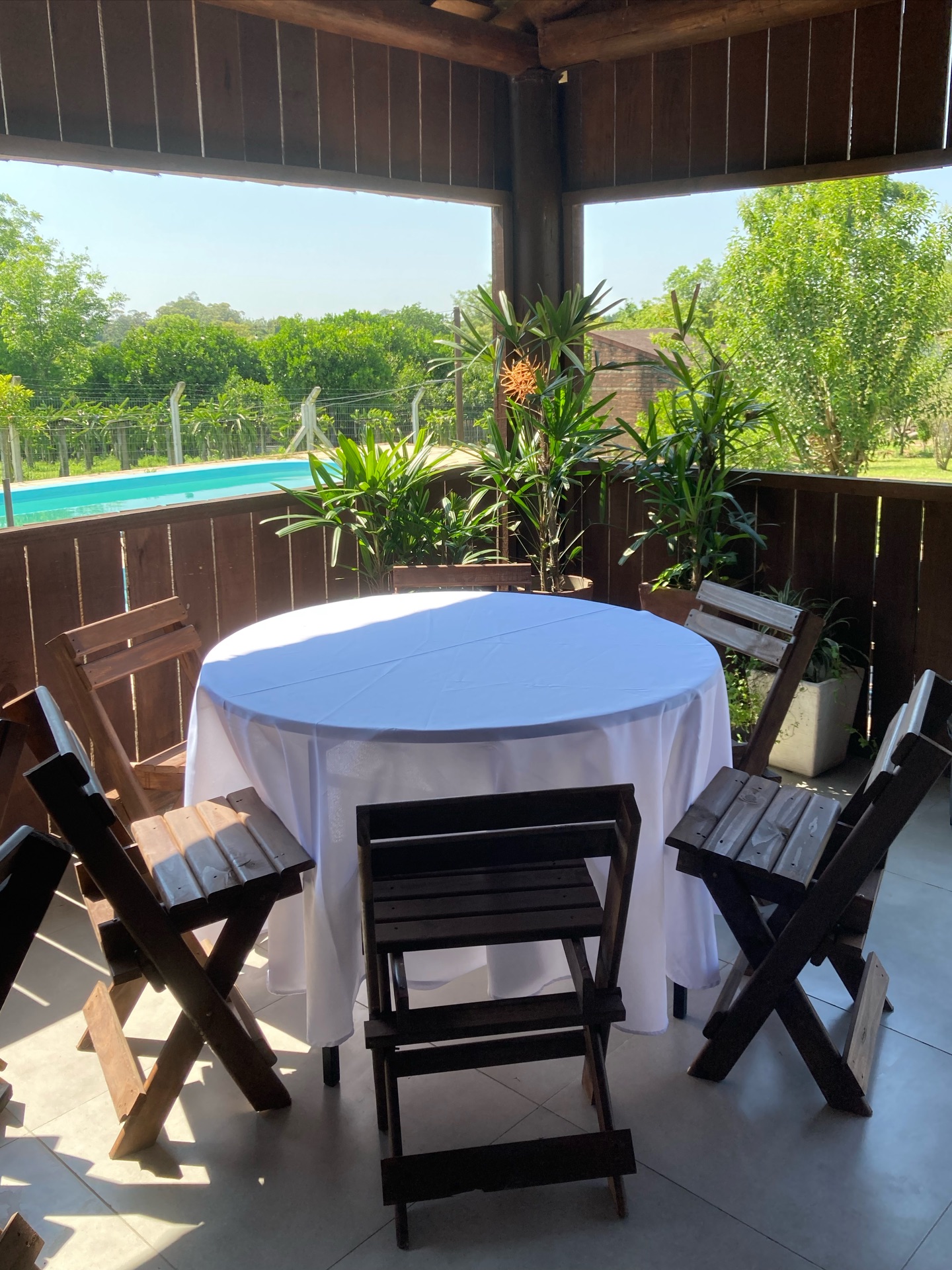 Mesa redonda na varanda com vista para a piscina