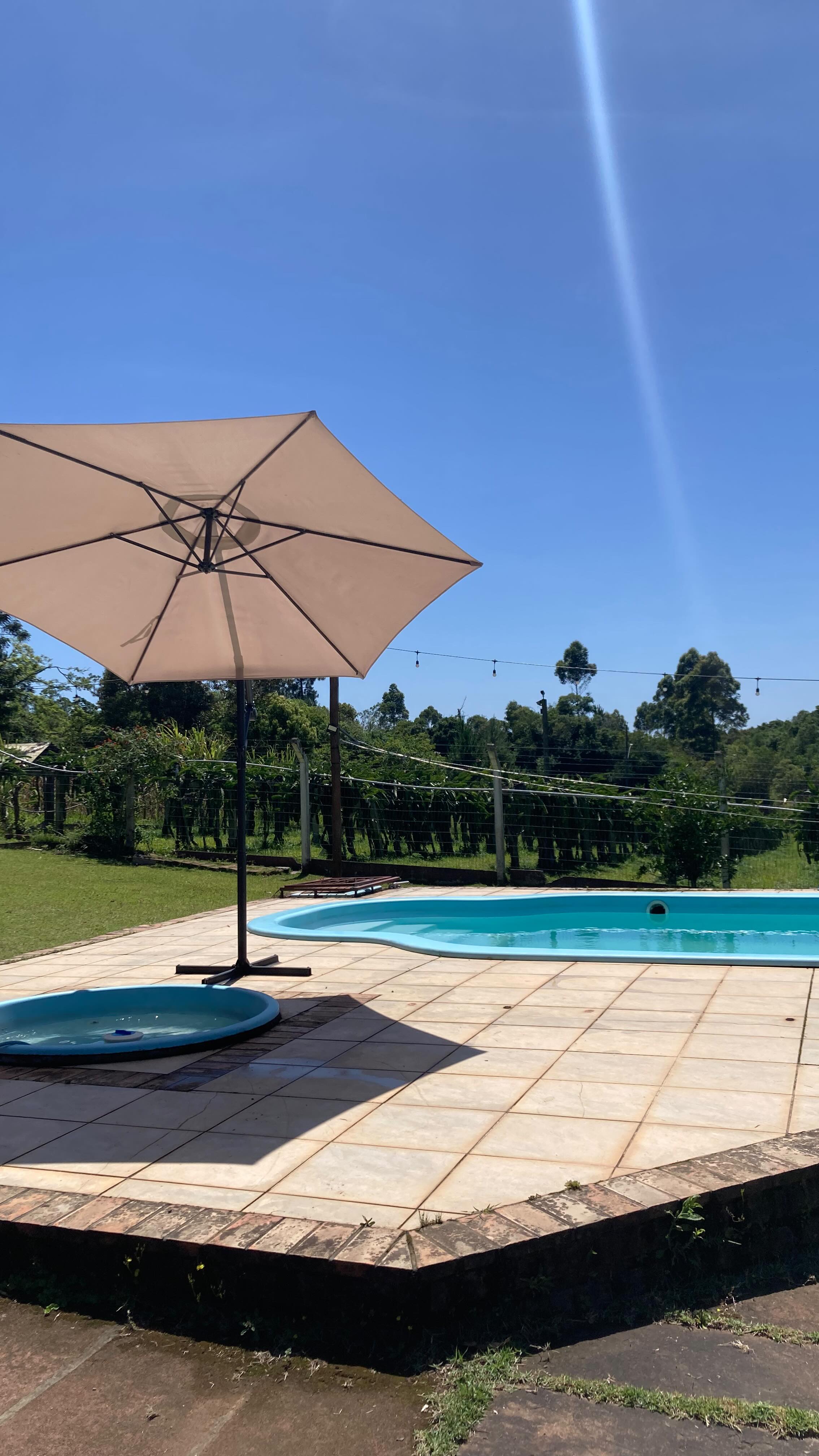 Guarda-sol ao lado da piscina